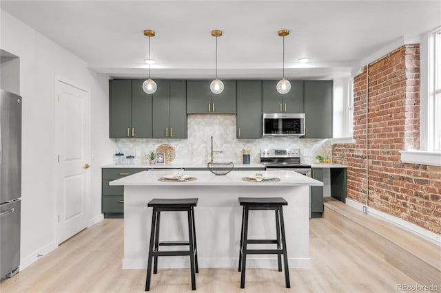 1210 E Colfax Ave Unit 104, Denver, CO 80218 - kitchen featuring stainless steel appliances, green cabinets, light wood-style flooring, light countertops, and backsplash