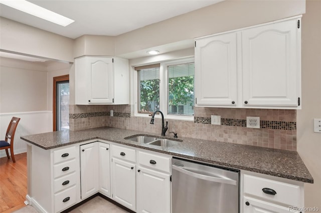 4895 S Galapago St, Englewood, CO 80110 - kitchen with stainless steel dishwasher, dark stone counters, a peninsula, and white cabinetry