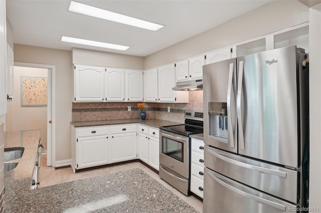 4895 S Galapago St, Englewood, CO 80110 - kitchen featuring appliances with stainless steel finishes, under cabinet range hood, dark stone counters, and white cabinets