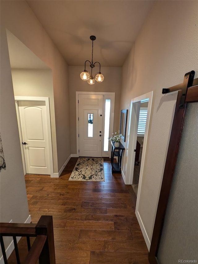 foyer featuring dark wood-style floors, baseboards, and an inviting chandelier