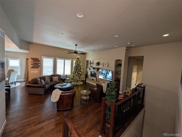 living room featuring dark wood-style floors, recessed lighting, a fireplace, and a healthy amount of sunlight