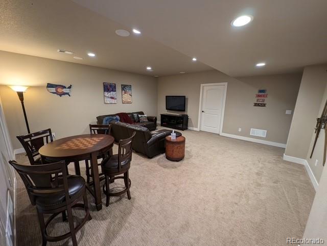 living room with visible vents, baseboards, light colored carpet, and recessed lighting