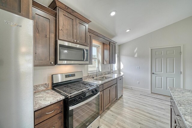 882 Hoover Cir, Poncha Springs, CO 81242 - kitchen featuring appliances with stainless steel finishes, a sink, light wood finished floors, light stone countertops, and baseboards
