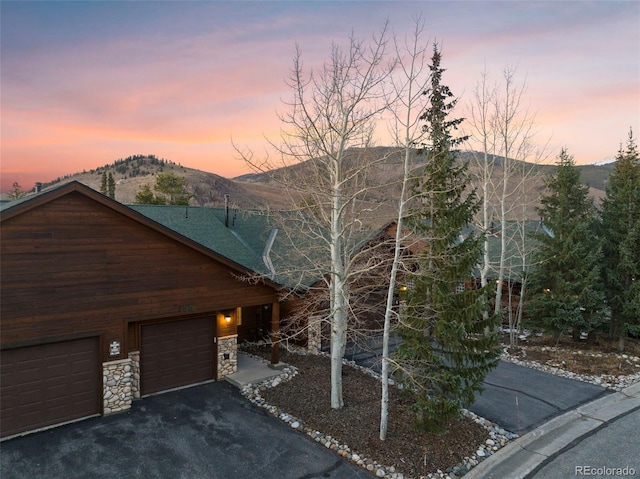 85 Lookout Ridge Dr, Dillon, CO 80435 - rustic home with stone siding, a mountain view, driveway, and a garage
