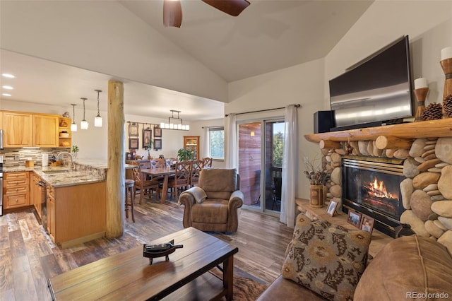 85 Lookout Ridge Dr, Dillon, CO 80435 - living room with wood finished floors, a ceiling fan, a stone fireplace, high vaulted ceiling, and a chandelier