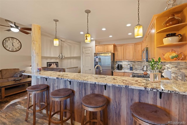 85 Lookout Ridge Dr, Dillon, CO 80435 - kitchen featuring appliances with stainless steel finishes, ceiling fan, decorative backsplash, a peninsula, and light stone counters