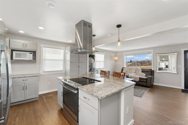 kitchen with baseboards, island range hood, a kitchen island, appliances with stainless steel finishes, and dark wood-style flooring