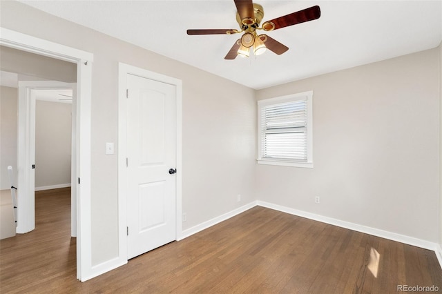 spare room with ceiling fan, baseboards, and wood finished floors