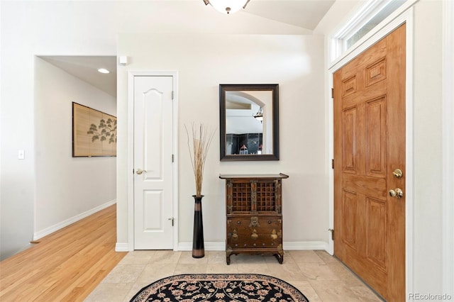 foyer featuring lofted ceiling and light tile patterned floors