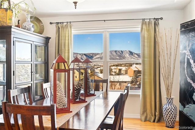 dining room with light wood-type flooring and a mountain view