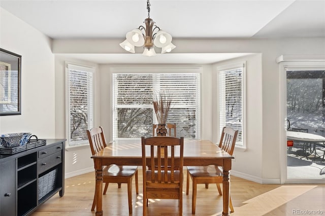 dining area with an inviting chandelier and light hardwood / wood-style flooring