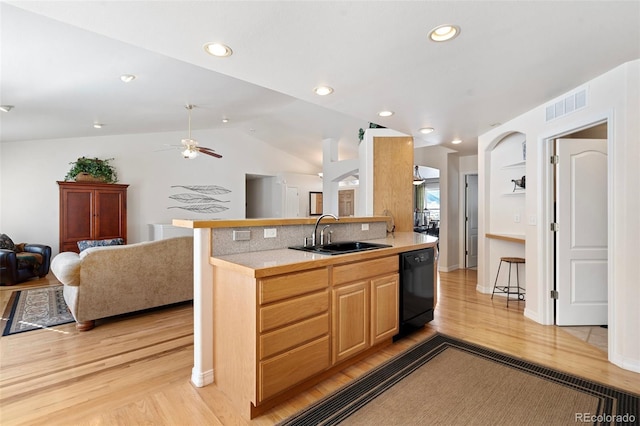 kitchen featuring lofted ceiling, light hardwood / wood-style floors, black dishwasher, and sink