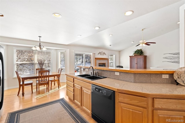 kitchen featuring vaulted ceiling, dishwasher, tasteful backsplash, light wood-type flooring, and sink