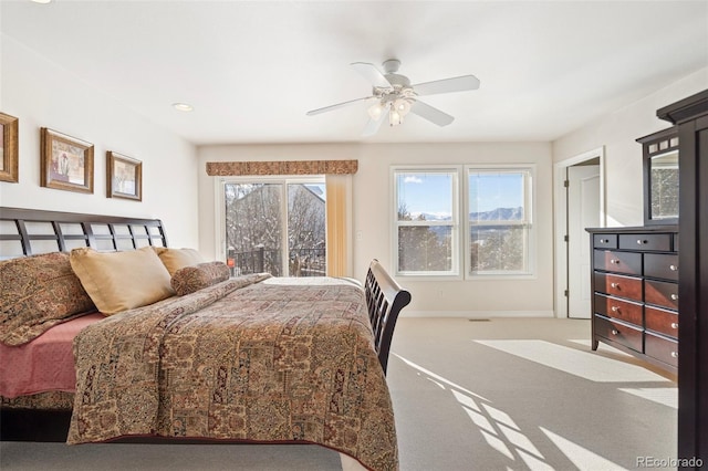 bedroom featuring ceiling fan, multiple windows, and carpet flooring