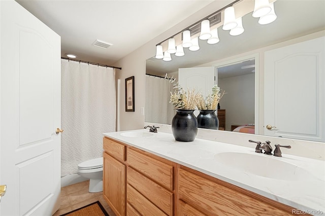 bathroom featuring toilet, tile patterned floors, and vanity