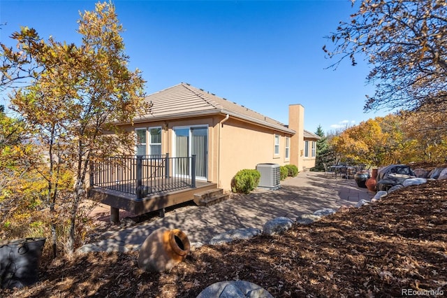 view of side of home with a patio, a deck, and central AC