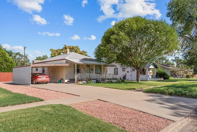 ranch-style home featuring a carport, a porch, and a front yard