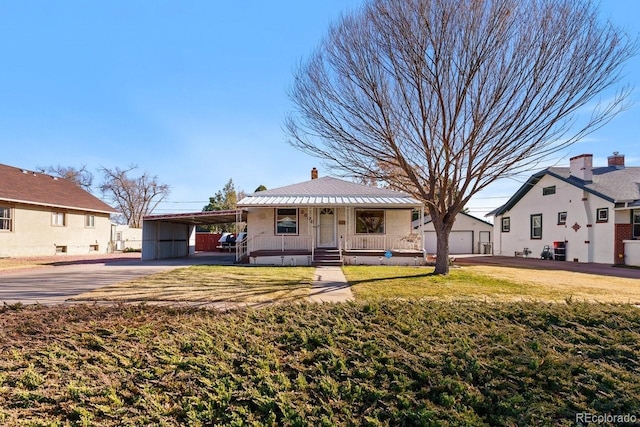 view of front of house with an outdoor structure, a front lawn, a porch, and a carport