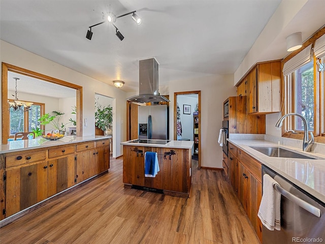 kitchen featuring island exhaust hood, stainless steel appliances, a wealth of natural light, sink, and light hardwood / wood-style floors