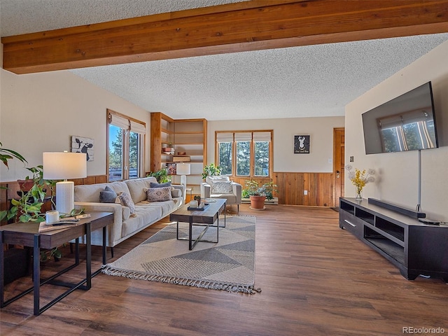 living room with hardwood / wood-style floors, wood walls, and a textured ceiling