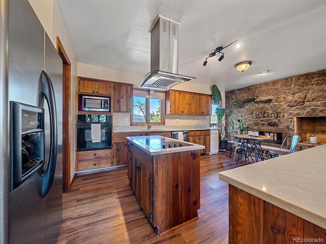 kitchen with dark hardwood / wood-style flooring, island range hood, black appliances, sink, and a kitchen island