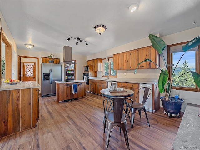 kitchen with island range hood, a center island, light hardwood / wood-style floors, and stainless steel appliances