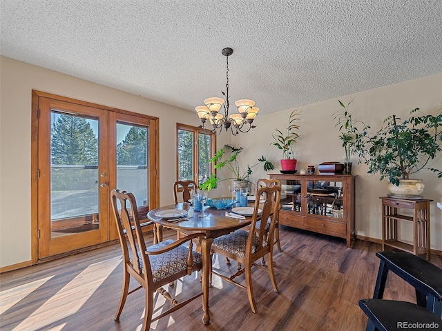 dining room with dark hardwood / wood-style flooring, a chandelier, a textured ceiling, and french doors