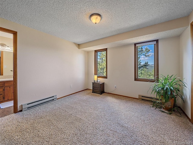 carpeted empty room with baseboard heating and a textured ceiling