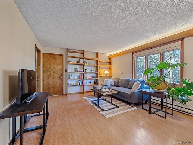 living room with a textured ceiling, light hardwood / wood-style flooring, and a baseboard heating unit