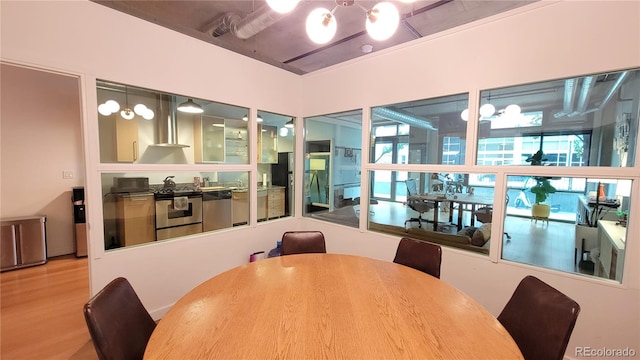 dining space featuring light hardwood / wood-style flooring, plenty of natural light, and a chandelier