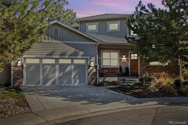 4193 W 99th Ct, Westminster, CO 80031 - view of front of property with brick siding, a porch, driveway, and a garage
