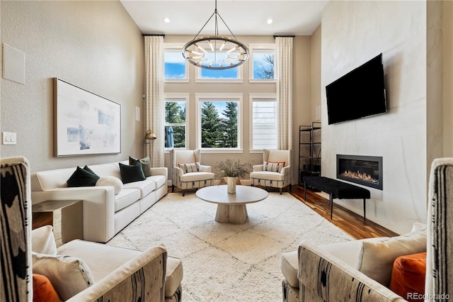 4193 W 99th Ct, Westminster, CO 80031 - living area with a chandelier, wood finished floors, plenty of natural light, a fireplace, and a towering ceiling