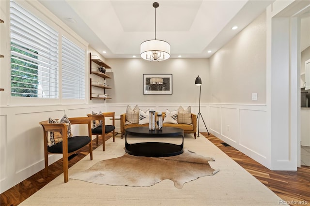 4193 W 99th Ct, Westminster, CO 80031 - living area featuring wood finished floors, a tray ceiling, a chandelier, a decorative wall, and recessed lighting