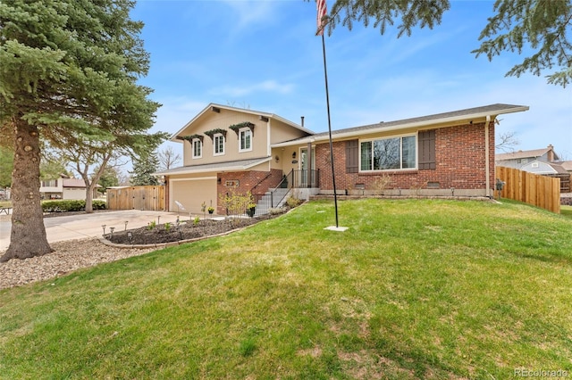 tri-level home with a garage, concrete driveway, fence, a front yard, and brick siding