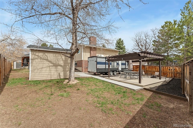 rear view of house with a pergola, a fenced backyard, a chimney, and a patio