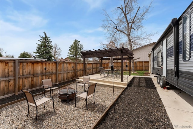 view of yard with a pergola, a fenced backyard, and a fire pit