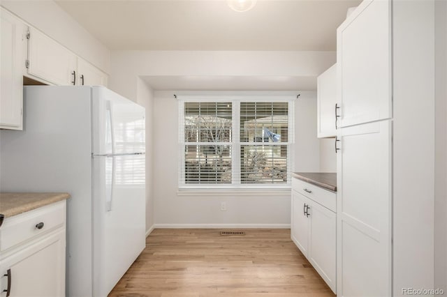 5316 S Jellison St, Littleton, CO 80123 - kitchen featuring freestanding refrigerator, light wood finished floors, baseboards, and white cabinetry