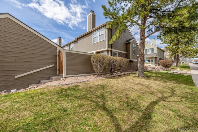 5316 S Jellison St, Littleton, CO 80123 - view of home's exterior featuring a lawn and a chimney