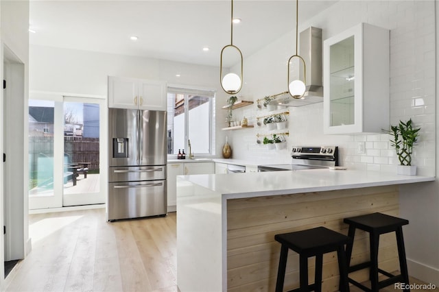 kitchen with a breakfast bar area, stainless steel appliances, kitchen peninsula, and white cabinets