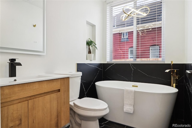 bathroom featuring vanity, a tub, tile patterned floors, and toilet