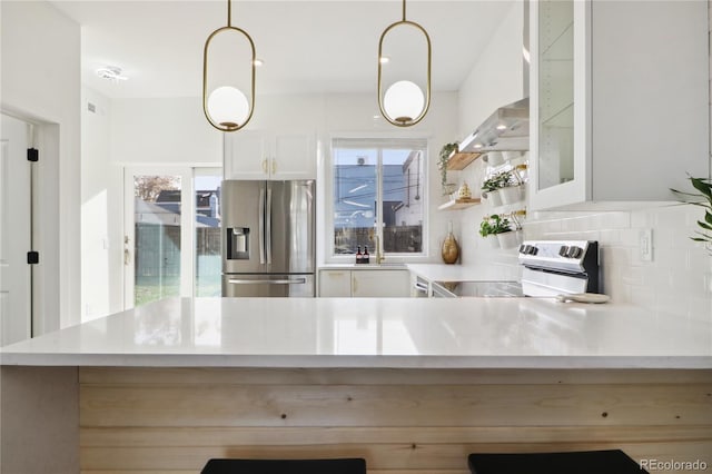 kitchen with stainless steel appliances, decorative light fixtures, a wealth of natural light, and backsplash