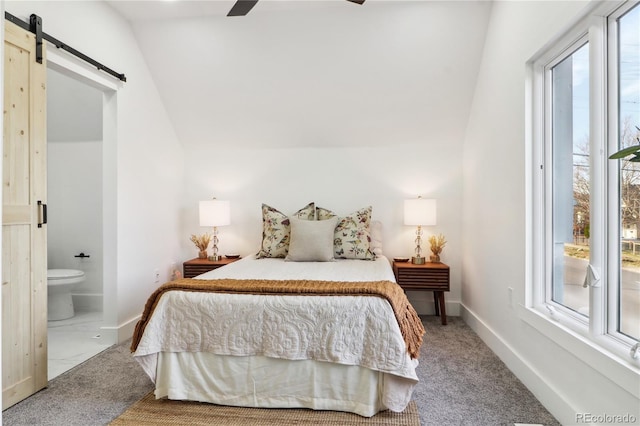 bedroom with ensuite bathroom, vaulted ceiling, carpet floors, ceiling fan, and a barn door