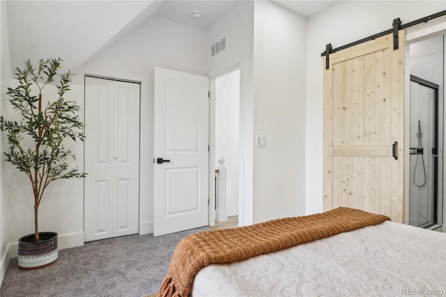 bedroom with carpet flooring, a barn door, vaulted ceiling, and a closet