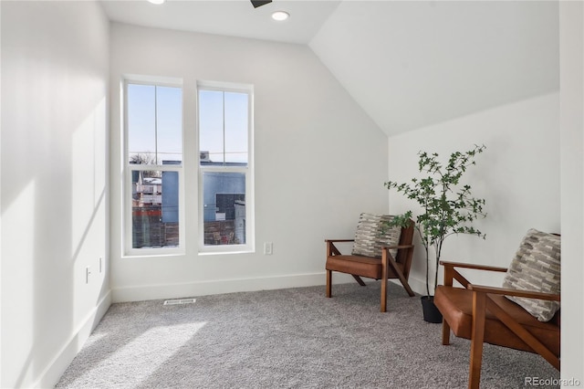 living area featuring vaulted ceiling and carpet