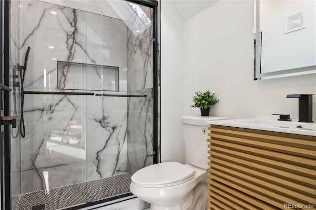 bathroom with vanity, a shower with shower door, and toilet