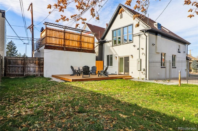 back of house with a wooden deck and a lawn