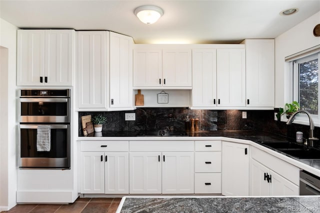 4545 S Lipan Ct, Englewood, CO 80110 - kitchen with double oven, a sink, black electric cooktop, white cabinets, and tasteful backsplash