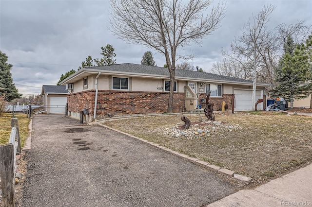 ranch-style house featuring a garage, brick siding, fence, and stucco siding