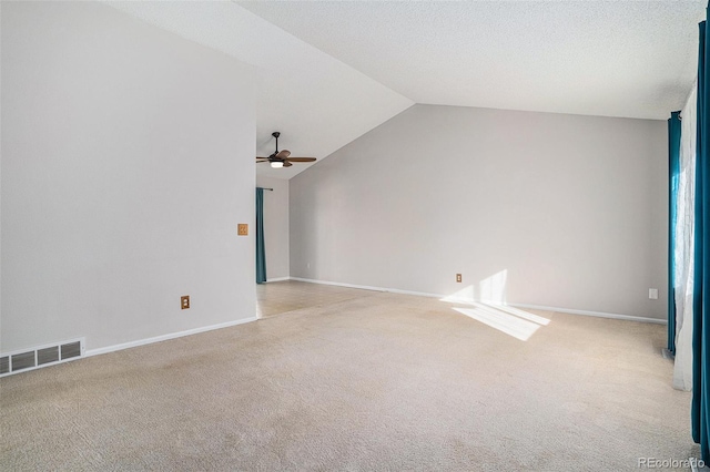 unfurnished living room featuring ceiling fan, light colored carpet, and vaulted ceiling