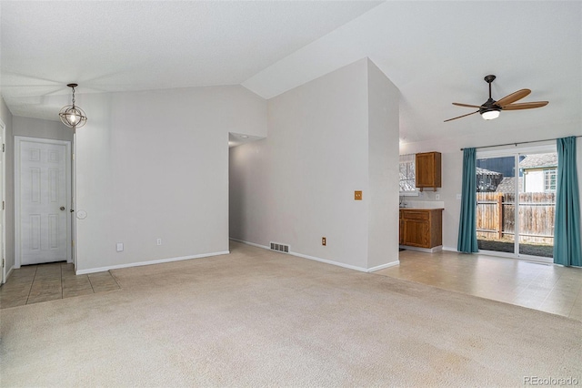 unfurnished living room featuring ceiling fan with notable chandelier, light tile patterned floors, and lofted ceiling